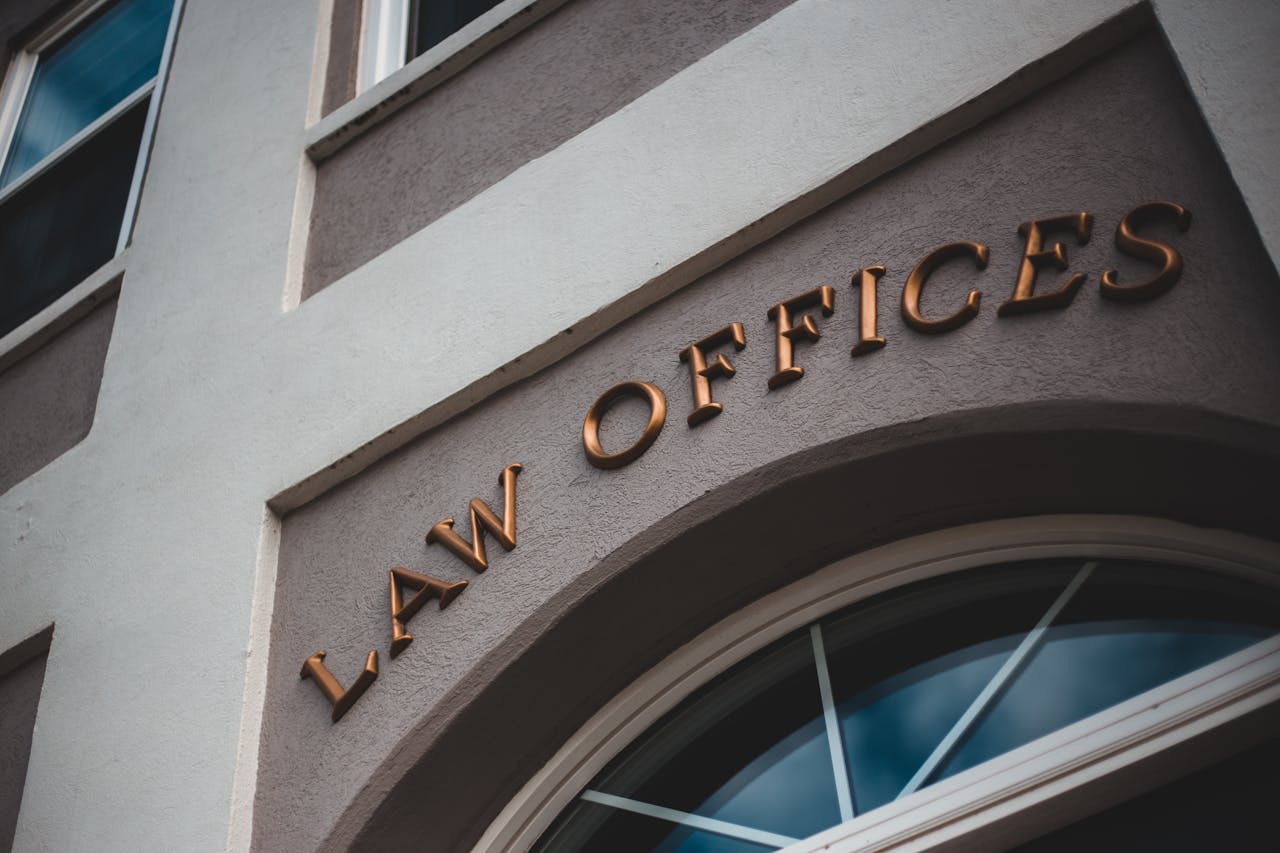 Home Low angle view of a modern law office exterior with elegant facade and arched entrance.