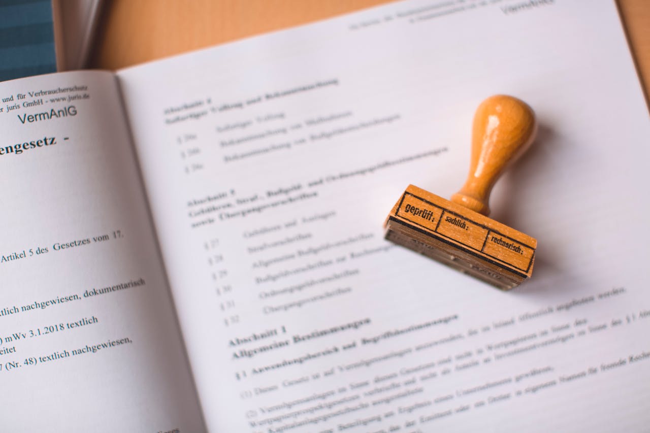 Home Close-up of a legal document with a wooden stamp placed on top, highlighting verification.